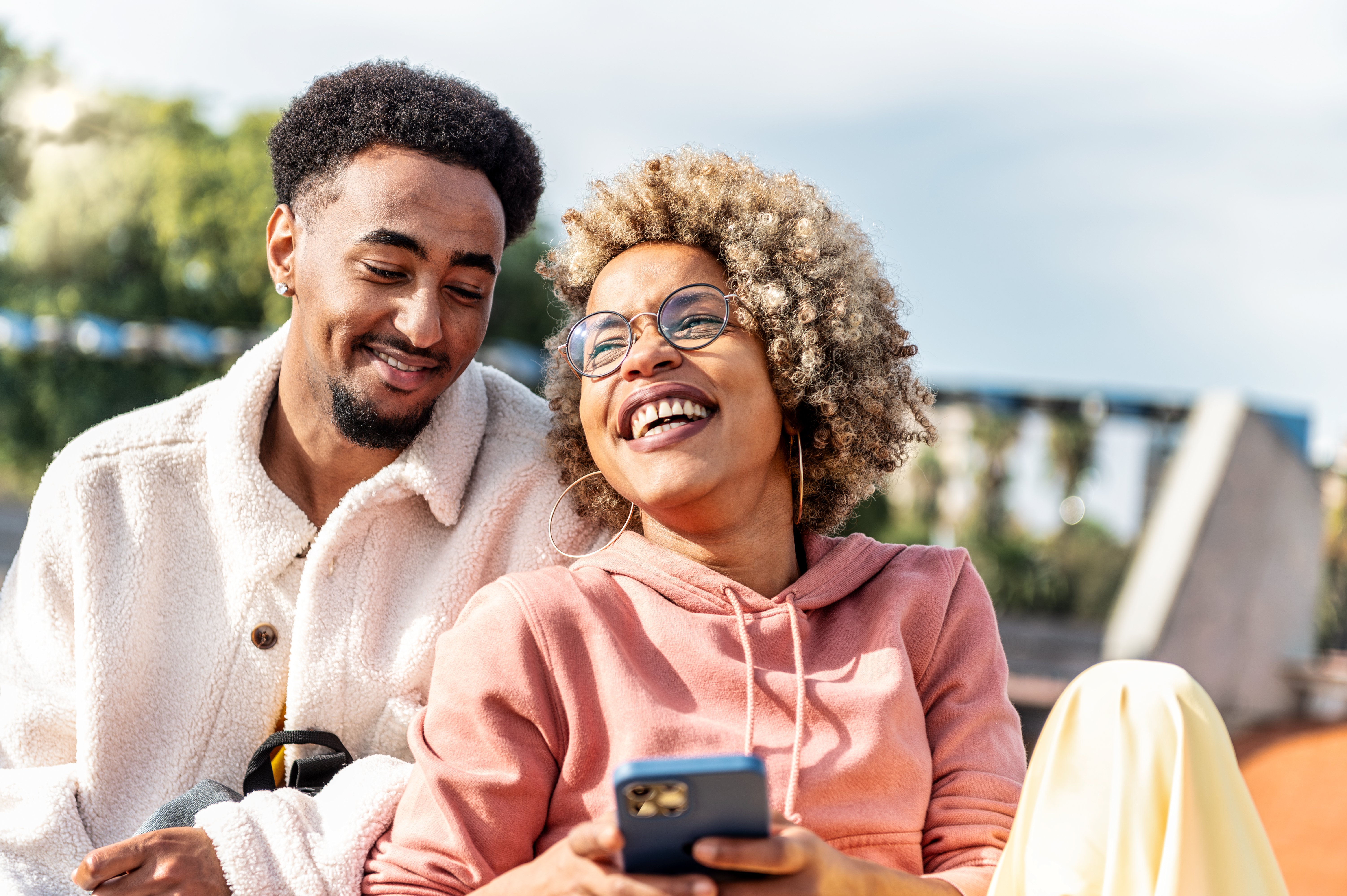 smiling couple outside on phone